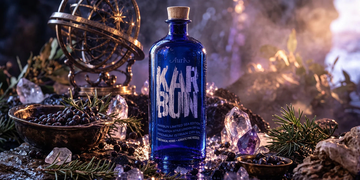 Aura Karbun Limited Sea Edition premium Istrian dry gin in a deep blue bottle displayed with juniper berries, pine needles, crystals and a dramatic coastal-inspired setting.