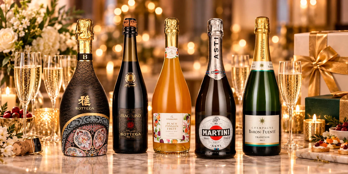 Premium sparkling wine selection featuring Bottega, Katlenburger Peach Passion Fruit, Martini Asti and Baron-Fuenté Champagne with filled flutes, flowers and elegant gift boxes in a festive celebration setting.