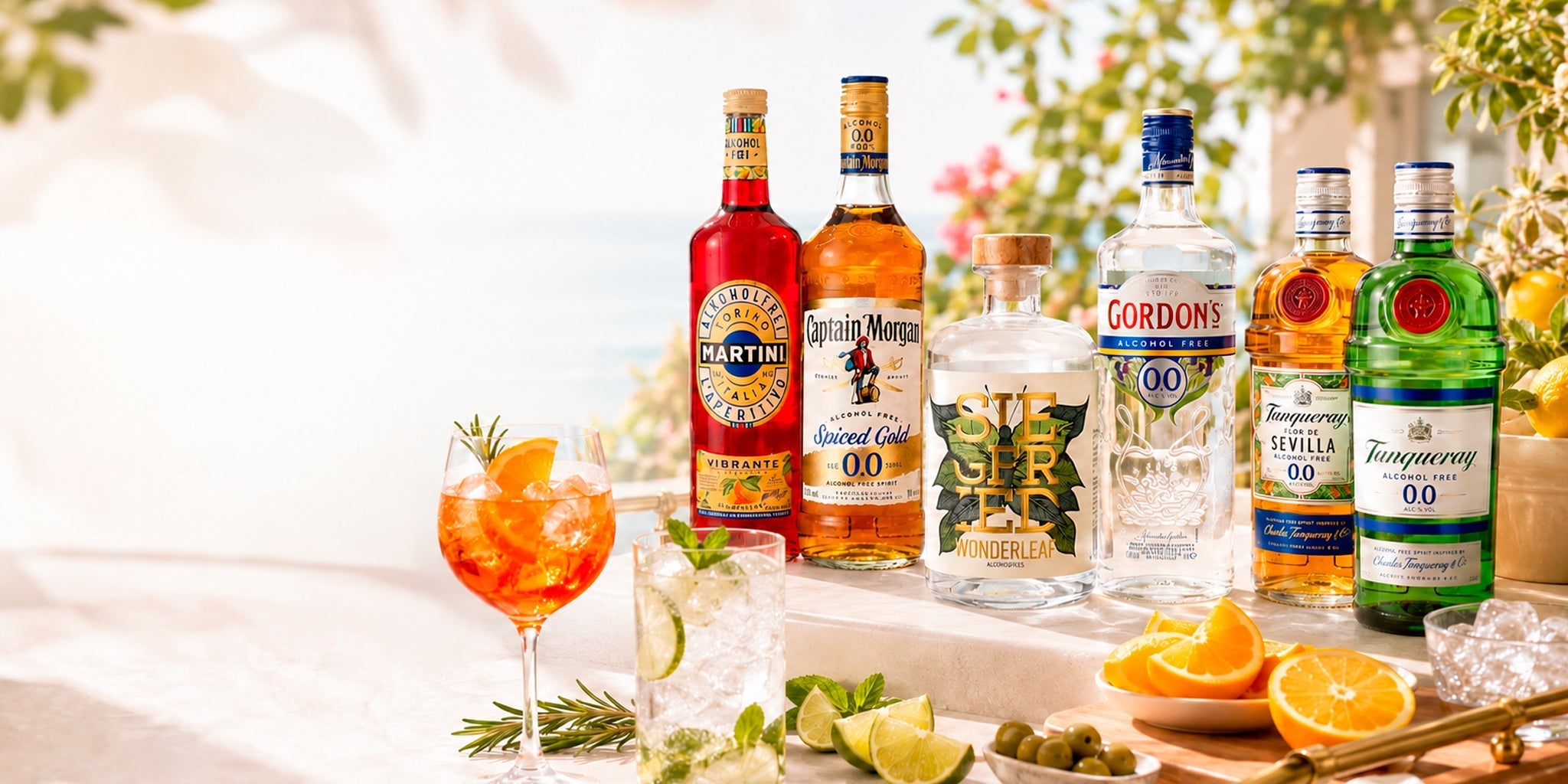 Zero-proof bar cart setup with Martini Vibrante, Captain Morgan 0.0, Siegfried Wonderleaf, Gordon’s 0.0 and Tanqueray 0.0 bottles with citrus, herbs and alcohol-free cocktails.